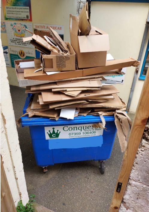 Overflowing trade waste bins with Conqueror Refuse & Waste branding in Hastings